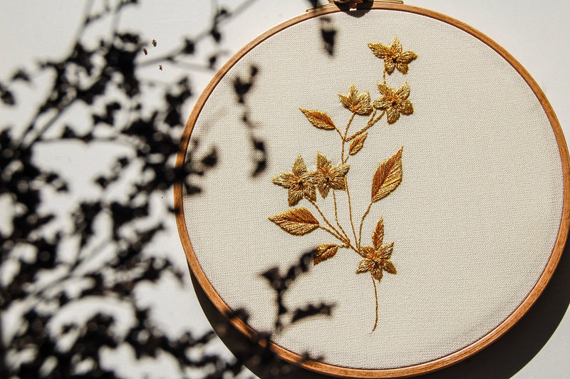 Botanical goldwork hand embroidery in a wooden hoop