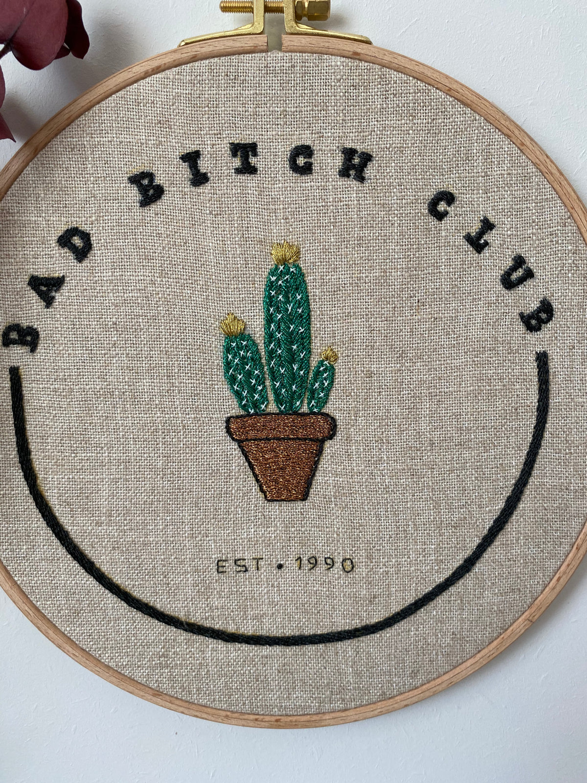 Close view of the Bad Bitch Club cactus hoop showing the stitched lettering and potted cactus