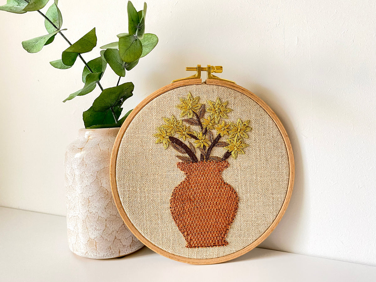 Floral hand embroidery design with terracotta vase in a wooden hoop