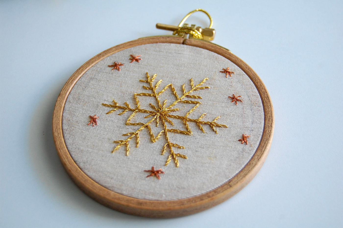 The golden snowflake hoop on a pale blue background