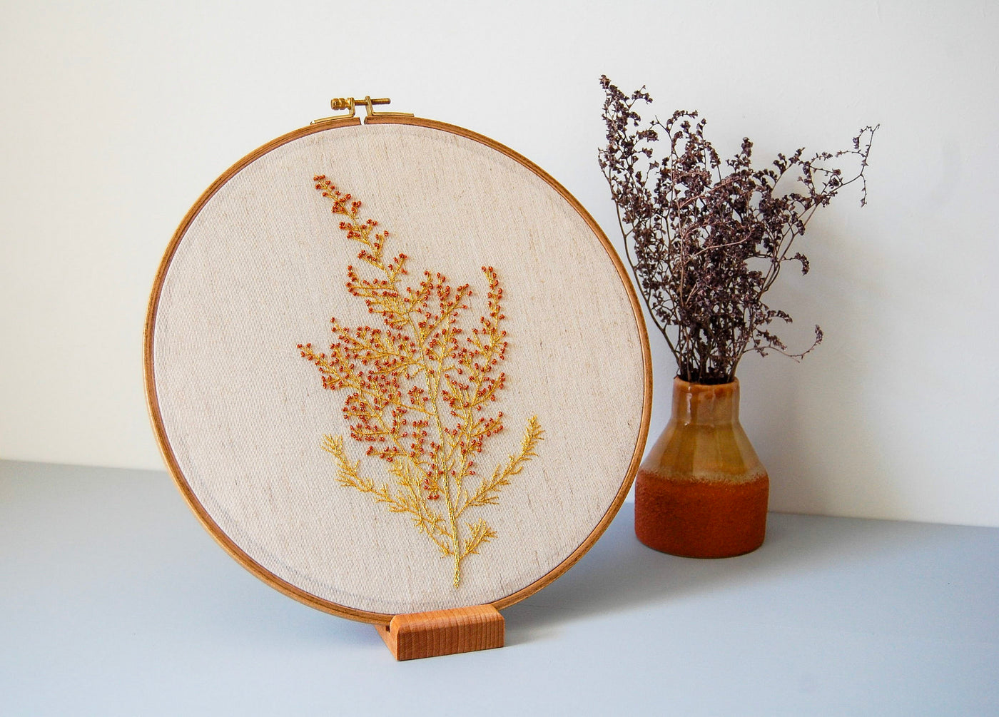 The wildflower spray hoop on a stand beside dried lavender in a terracotta vase