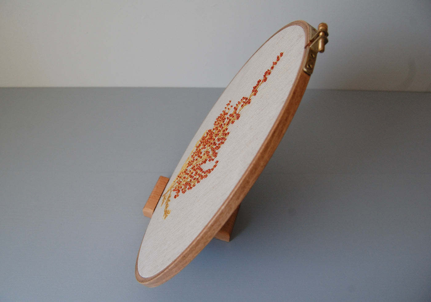 The wildflower spray hoop on its stand, seen edge-on against a pale background