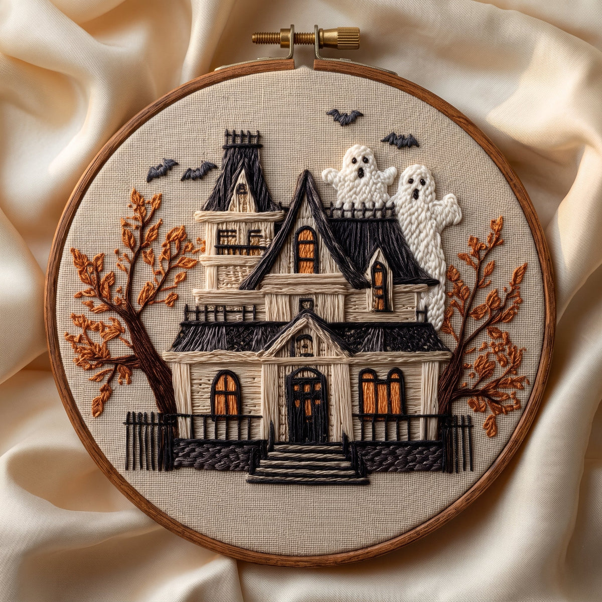 Haunted house with bats and two ghosts among autumn trees, finished hand embroidery hoop photographed in full